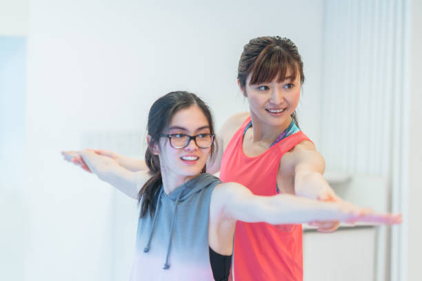 Female yoga instructor teaching yoga A female yoga instructor is teaching yoga. yoga instructor stock pictures, royalty-free photos & images