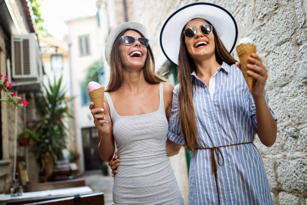 istock Two young female friends having fun and eating ice cream. 1136558174
