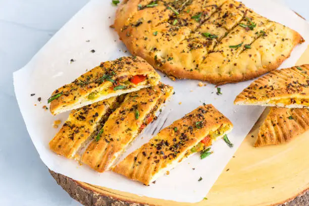 Garlic Bread and Garlic Bread Slices on a Wooden Top. Stuffed Garlic Bread with Cheese and Herbs High Angle and Horizontal Photo.