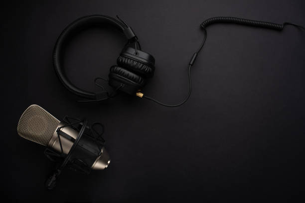 istock Microphone with headphones. Studio recording, broadcasting, blog, speaker. On a black background 1136559619
