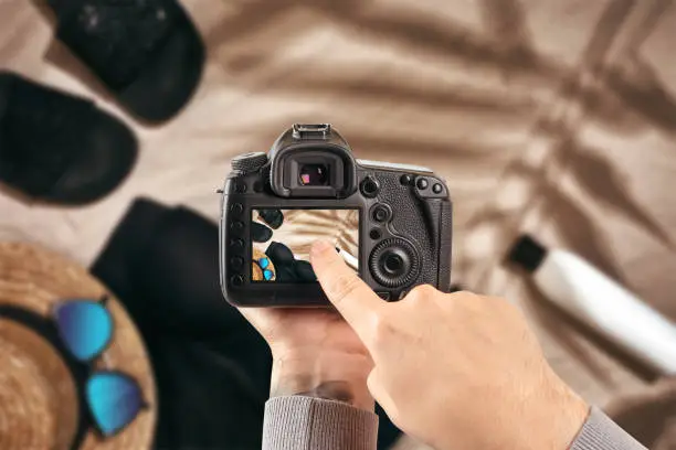 Photo of Digital single-lens reflex camera in hands. Man photographer makes photos. Male hands hold the camera close-up