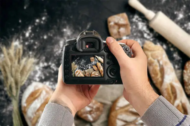 Photo of Digital single-lens reflex camera in hands. Man photographer makes photos. Male hands hold the camera close-up