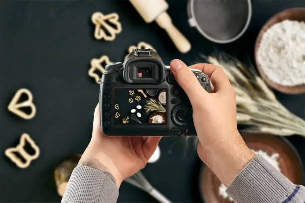 Photo of Digital single-lens reflex camera in hands. Man photographer makes photos. Male hands hold the camera close-up