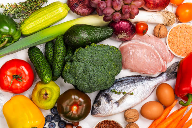 pegan comida dietética sobre mesa blanca - dieta paleolítica fotografías e imágenes de stock