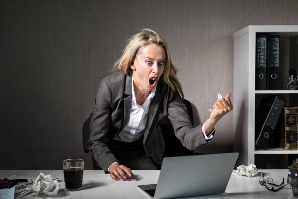 frau wütend auf ihrem laptop bei der arbeit - frustration office worker women business stock-fotos und bilder