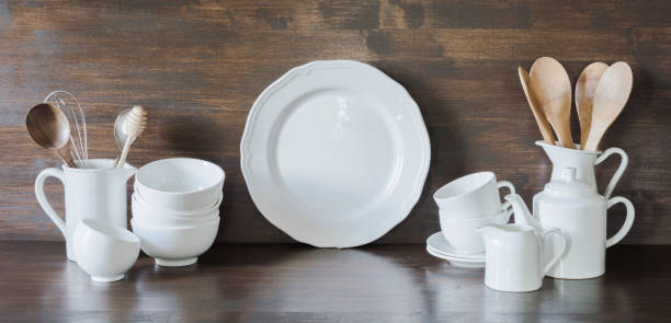 istock Crockery, clayware, white utensils and other different stuff on wooden tabletop. Kitchen still life. 1136561844