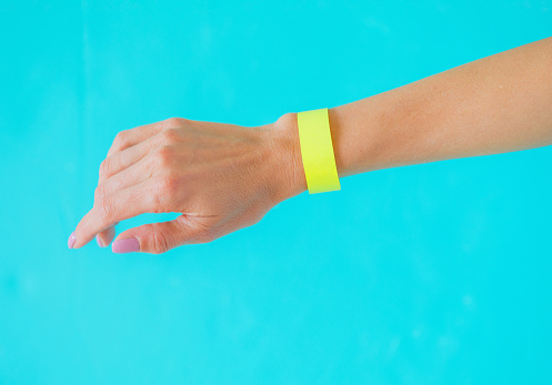Close up photo of woman's hand with yellow arm bracelet wristband, template for your design