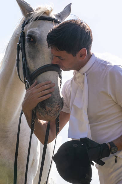 istock Horseback rider kissing white horse's head 1136562191