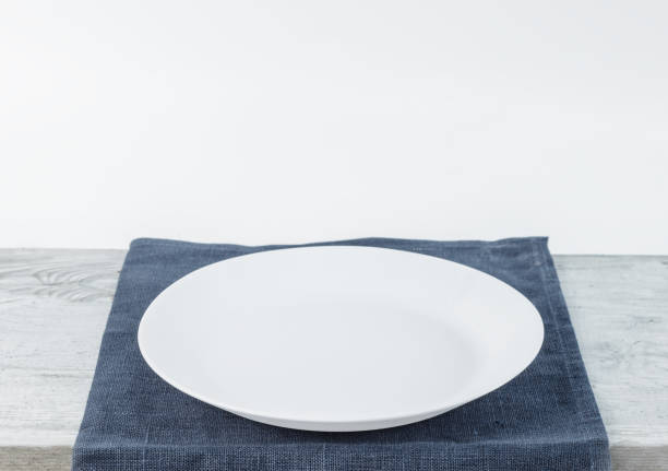 istock Empty plate on tablecloth on wooden table over grunge background 1136563044