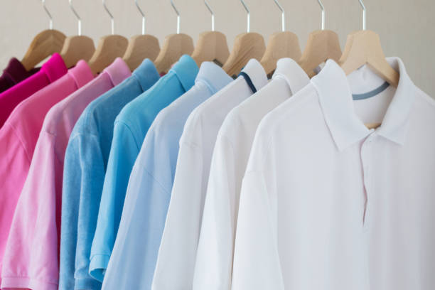 camicie da uomo appese al rack di fila - polo shirt multi colored clothing variation foto e immagini stock