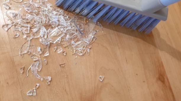 istock Brush sweeping up broken glass on wooden floor 1136563632