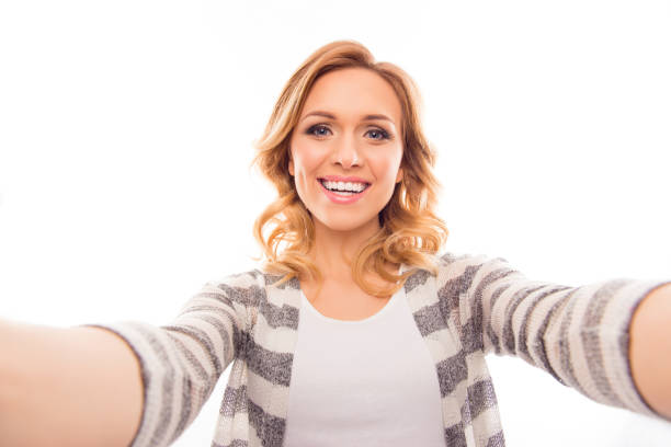 istock Pretty young woman making  selfie on white background 1136565573