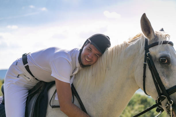 istock Man in the saddle leaning happily on the horse 1136566718