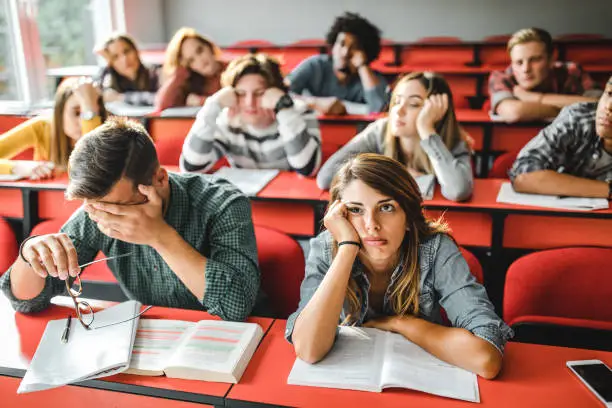 Photo of Large group of bored students at lecture hall.