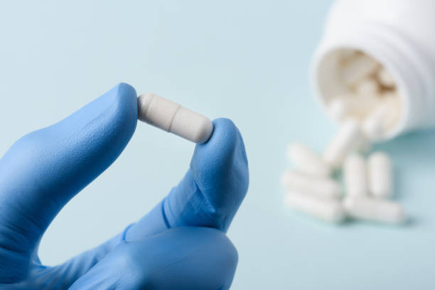 istock One capsule in doctor hand in protective glove 1136569280