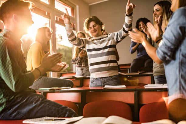 istock Happy students applauding their classmate at lecture hall. 1136570170