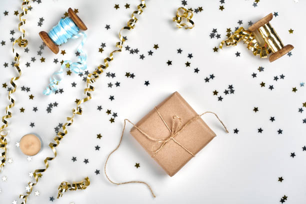 istock Delicate wavy ribbons and metallic star shaped confetti isolated on white background. Christmas holidays decoration concept. 1136570263