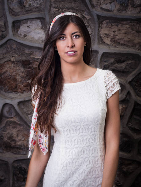 istock pretty brunette girl with brick wall background 1136570924
