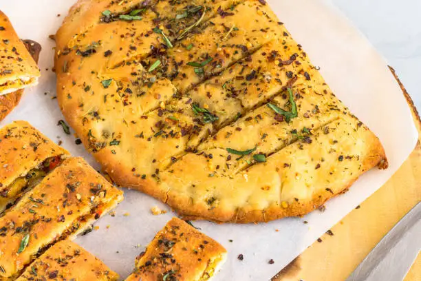 Garlic Bread and Garlic Bread Slices on a Wooden Top. Stuffed Garlic Bread with Cheese and Herbs High Angle and Horizontal Photo."n