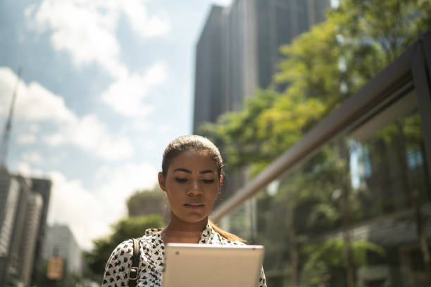 istock Young businesswoman using tablet at street 1136573164