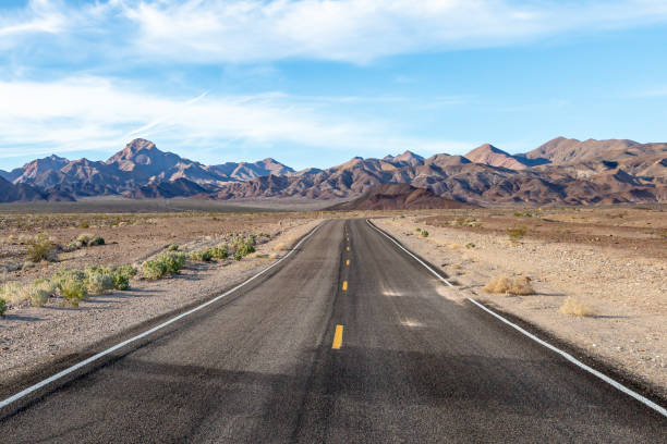 A Death Valley Landscape A road in Death Valley National Park, California, with rugged mountains in the distance death valley desert photos stock pictures, royalty-free photos & images