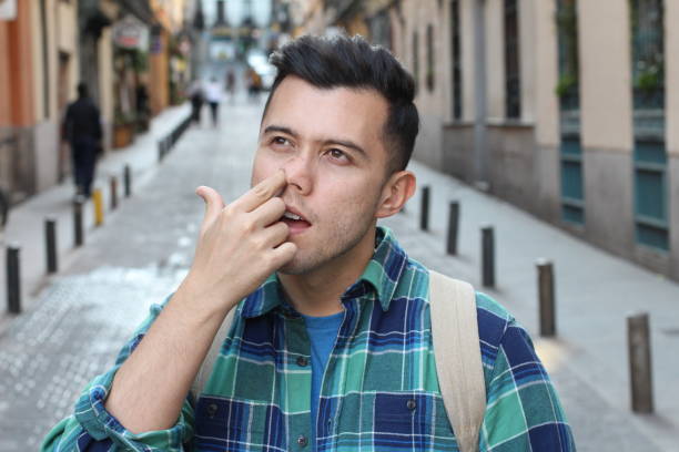 hombre recogiendo su nariz al aire libre - picking nose fotografías e imágenes de stock