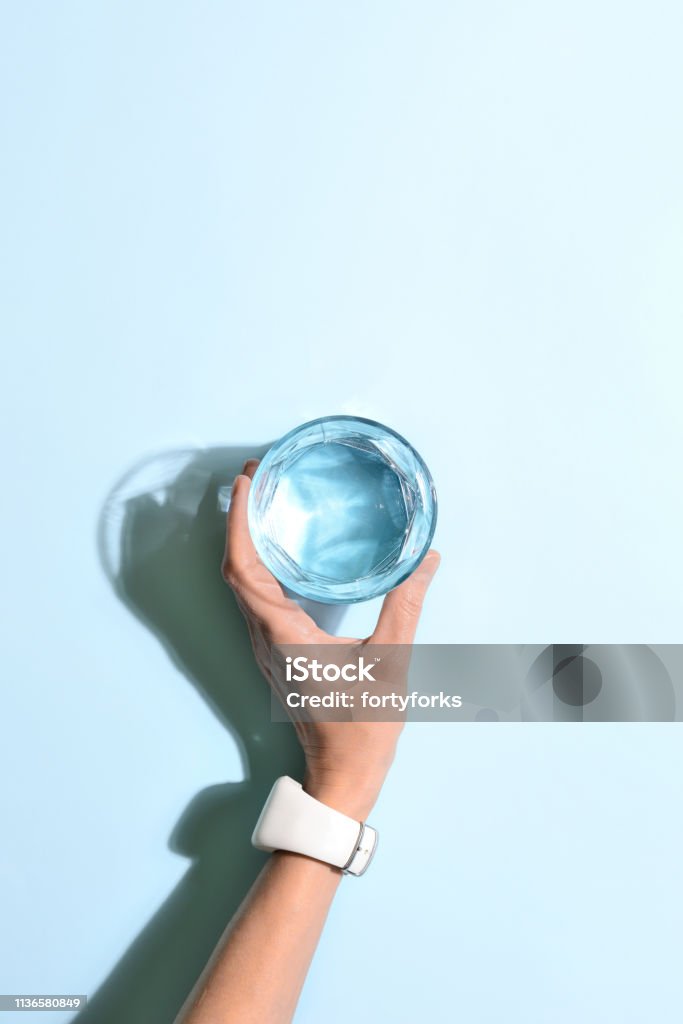 Healthy body hydration level keeping concept Woman's hand holding a glass of water, minimalist concept, view from above, blank space for a text Water Stock Photo