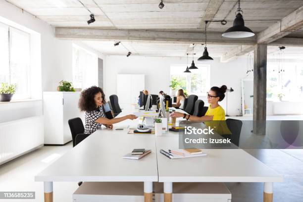 Businesswomen Working At Modern Workplace Stock Photo - Download Image Now - Office, Busy, Giving