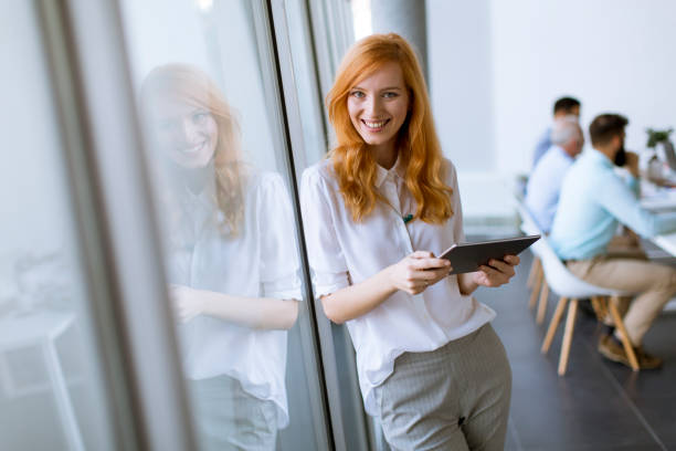 istock Pretty young red hair woman using digital tablet 1136586024