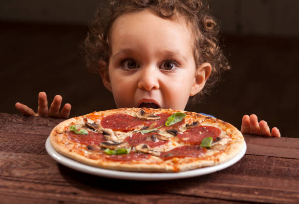 istock Boy ready to eat a pepperoni pizza 1136586743
