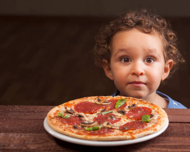 istock Boy ready to eat a pepperoni pizza 1136586749