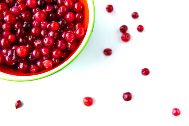 Top view. Raw Organic Red Cranberries in a red Bowl on the white background with berries