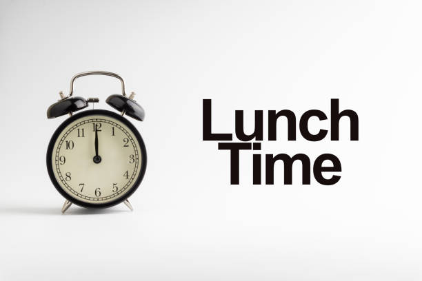 istock LUNCH TIME inscription written and alarm clock on white background. 1136590067