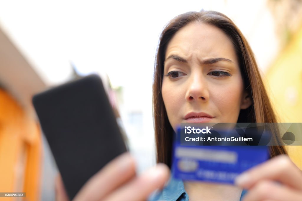 Mujer sospechosa paga en línea con tarjeta de crédito en la calle - Foto de stock de Sospecha libre de derechos