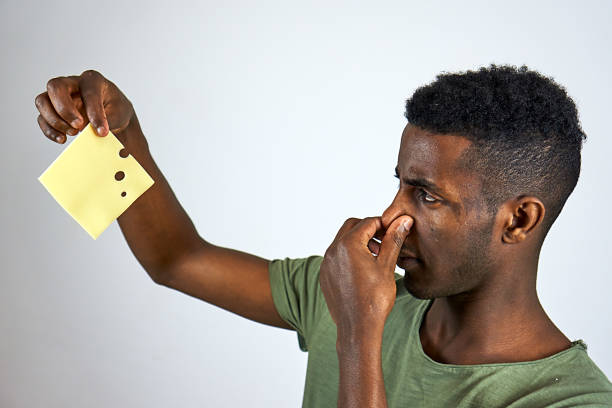 Stink Young Ethiopian with cheese holding nose stock pictures, royalty-free photos & images