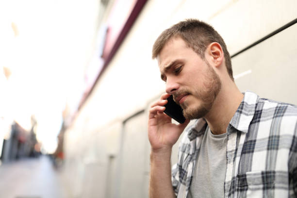 homme triste parlant au téléphone dans la rue - depression teenager sadness men photos et images de collection