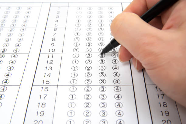 istock Man is filling OMR sheet handing with pen. 1136591026