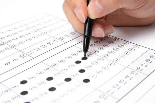 istock Man is filling OMR sheet handing with pen. 1136591568
