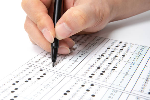 istock Man is filling OMR sheet handing with pen. 1136591622