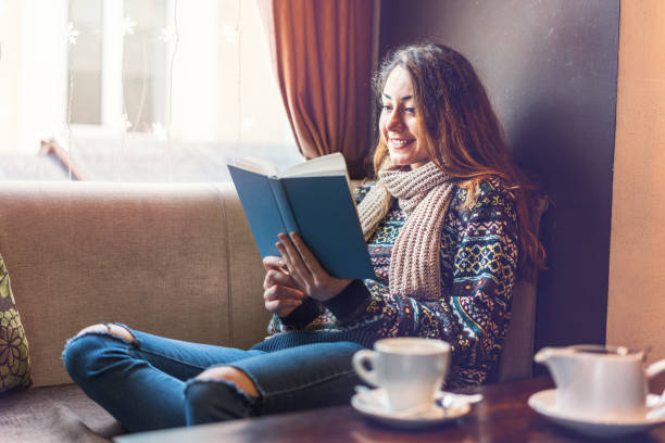 istock Woman relaxing on the couch and reading book 1136592179