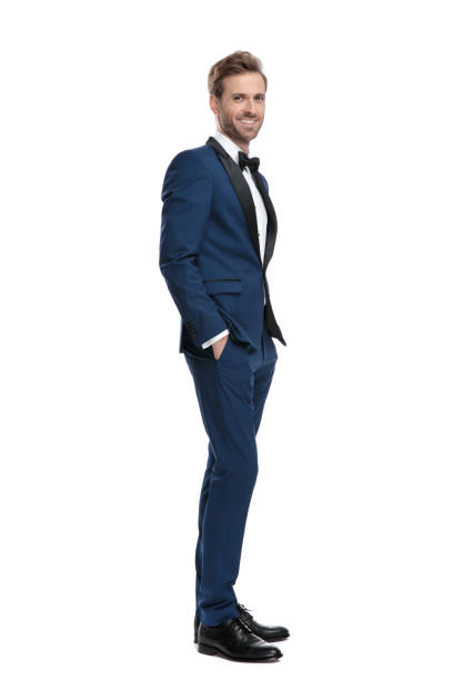 istock attractive man in blue costume standing with hands in pockets 1136593516