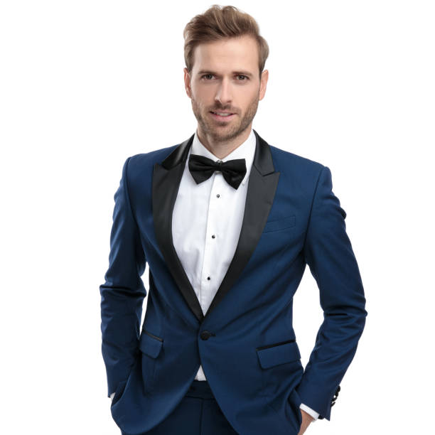 istock elegant man in blue suit standing with hands in pockets 1136593786