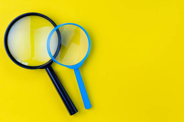 istock Black and bue magnifying glass, magnifier on yellow background with copy space using as search, transparent, science discovery or SEO concept 1136595301
