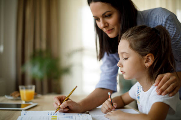 istock Mother helping daughter with homework 1136595351