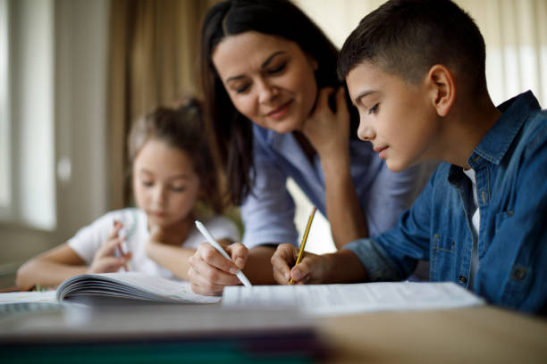 istock Mother helping her kids with homework 1136595454