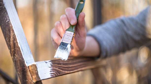 istock male hand paints with white paint on wood 1136596573