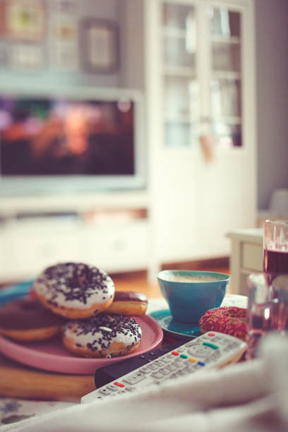istock Colourful donuts, coffee and lemonade for a cozy TV afternoon 1136596598