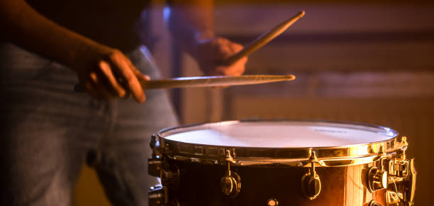 mann spielt die snare-trommel auf einem schönen farbigen hintergrund - rhythm section stock-fotos und bilder