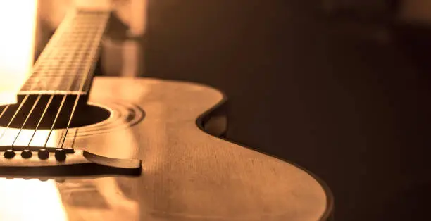 Photo of acoustic guitar close-up on a beautiful colored background