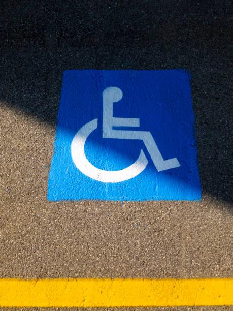 istock Disabled blue parking sign painted on dark asphalt in Italy 1136598134
